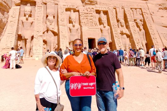 Visitors with WOW Tours Egypt in front of Abu Simbel Temples in Aswan, standing before the colossal statues of Ramses II during a private guided tour.