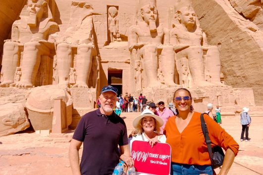 Visitors with WOW Tours Egypt in front of Abu Simbel Temples in Aswan, standing before the colossal statues of Ramses II during a private guided tour.
