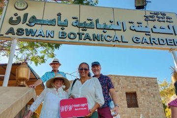 Group of travelers standing at the entrance sign of Aswan Botanical Garden, smiling during a guided visit on Kitchener’s Island in Aswan. // Aswan front (4)