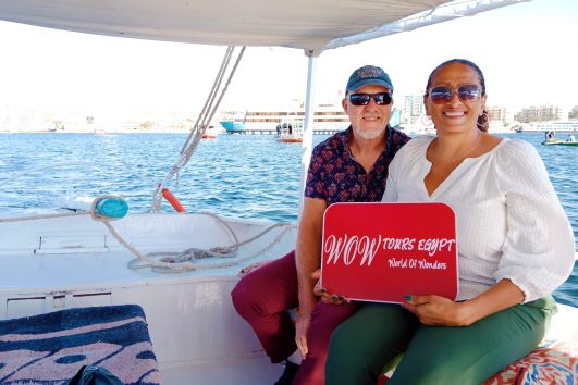 Tourists enjoying a private felucca boat ride on the Nile in Luxor holding WOW Tours Egypt sign // Cairo Front (7)