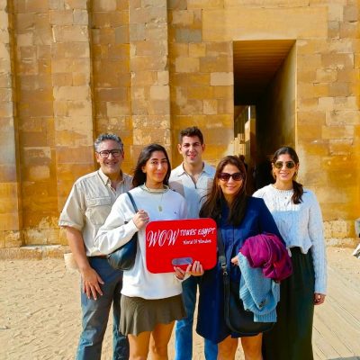 Happy travelers with WOW TOURS EGYPT standing at the entrance of the Step Pyramid complex in Saqqara, Egypt.