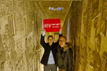 Two travelers stand inside a narrow, hieroglyph covered passageway of the Temple of Hathor in Dendera, // Luxor front (6)
