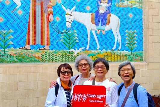 Group of women travelers smiling with WOW Tours Egypt sign at the Hanging Church in Coptic Cairo
