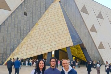 Guests posing at the Grand Egyptian Museum entrance in Giza with WOW Tours Egypt.
