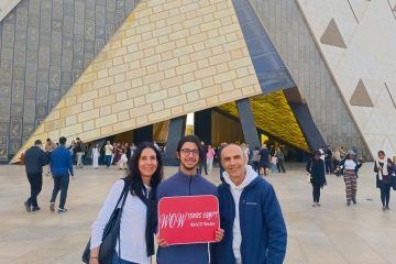 Guests posing at the Grand Egyptian Museum entrance in Giza with WOW Tours Egypt.